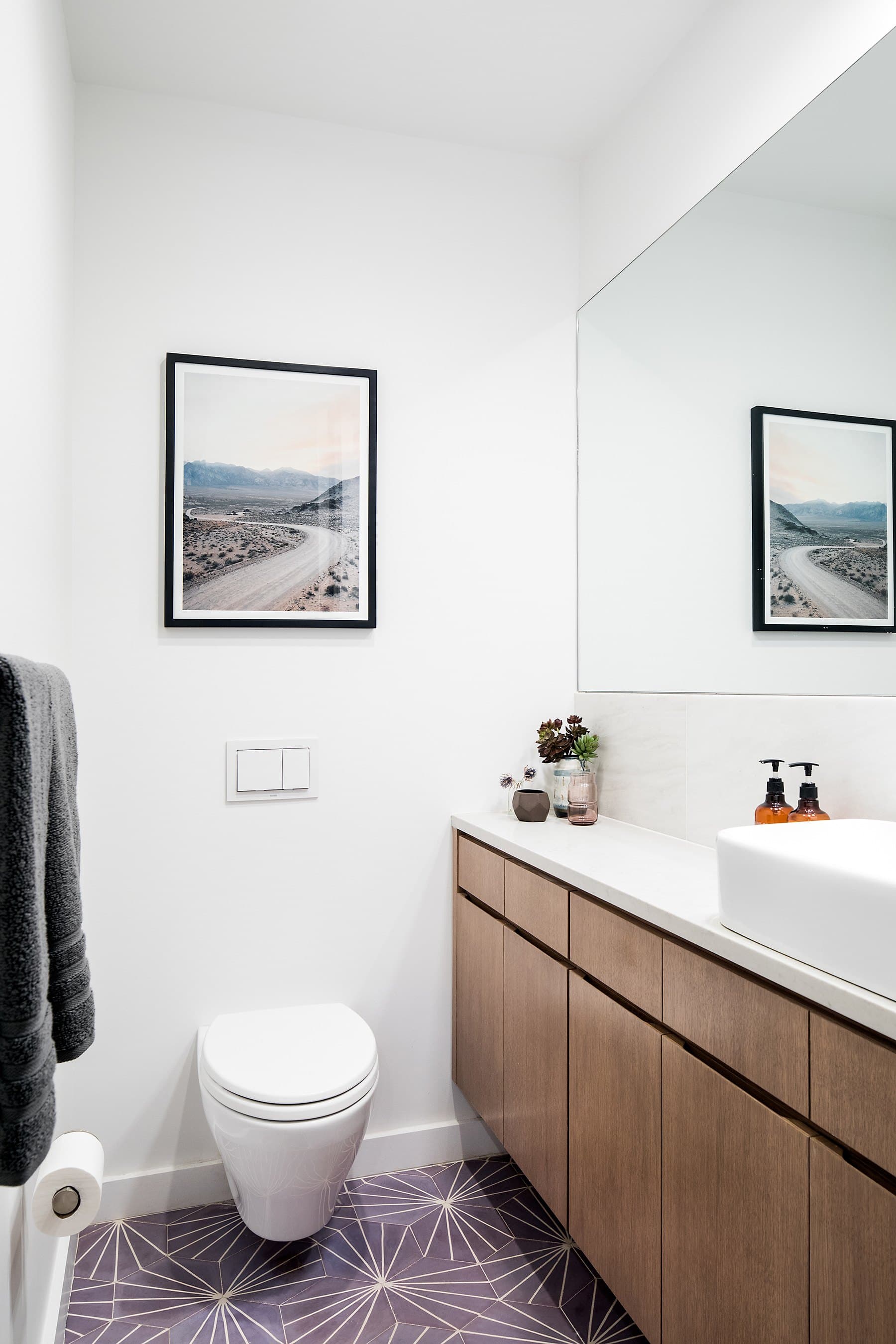 Powder room with a wall-hung toilet and a coastal print