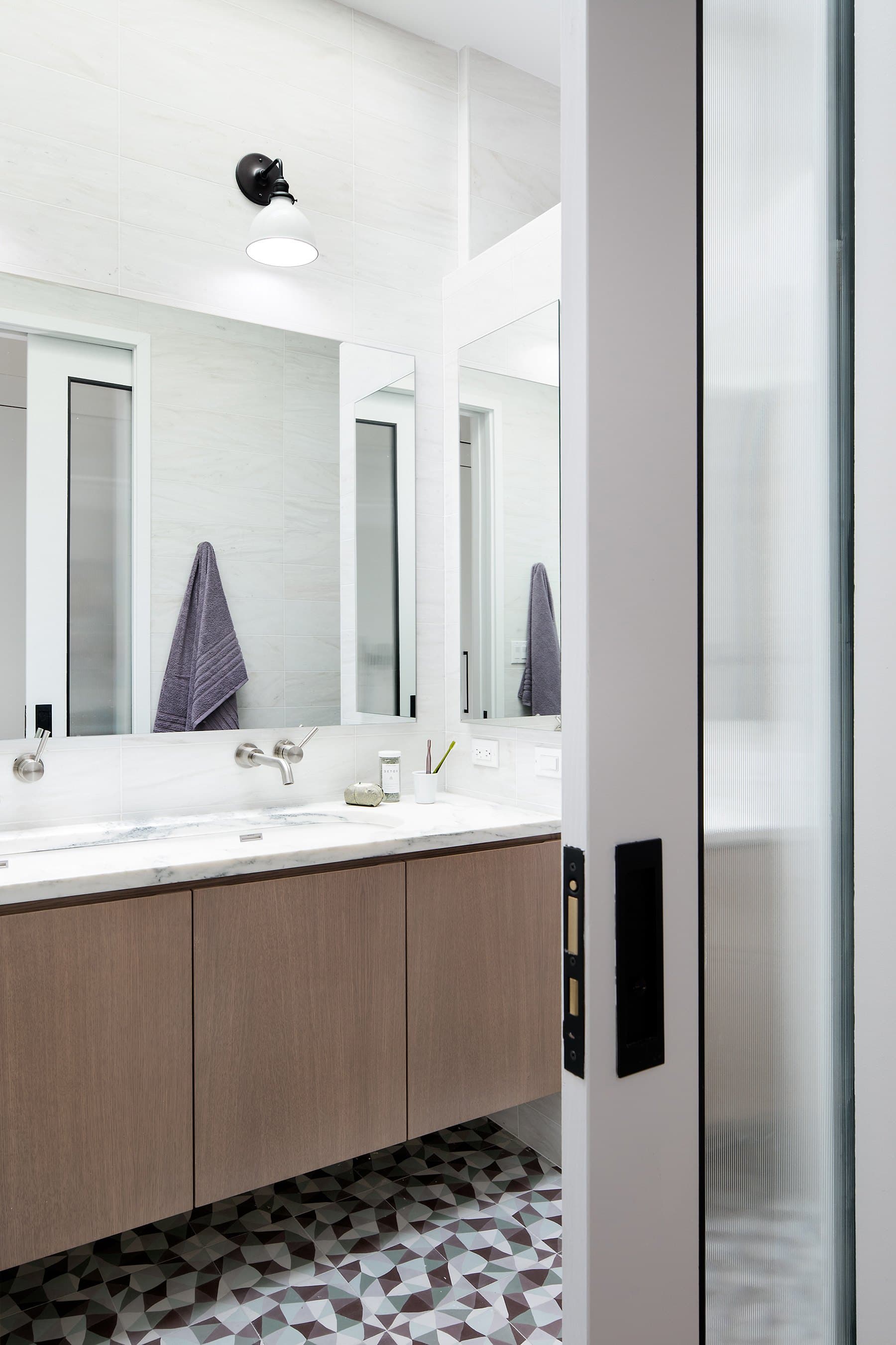 Primary bath with a wood vanity and patterned tile