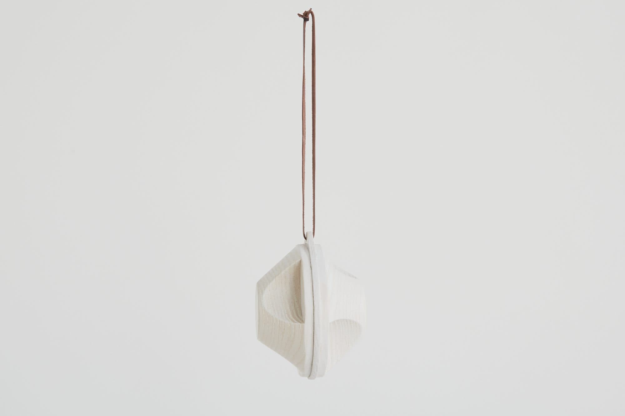 Folded white ornament on a leather cord by 100xBTR