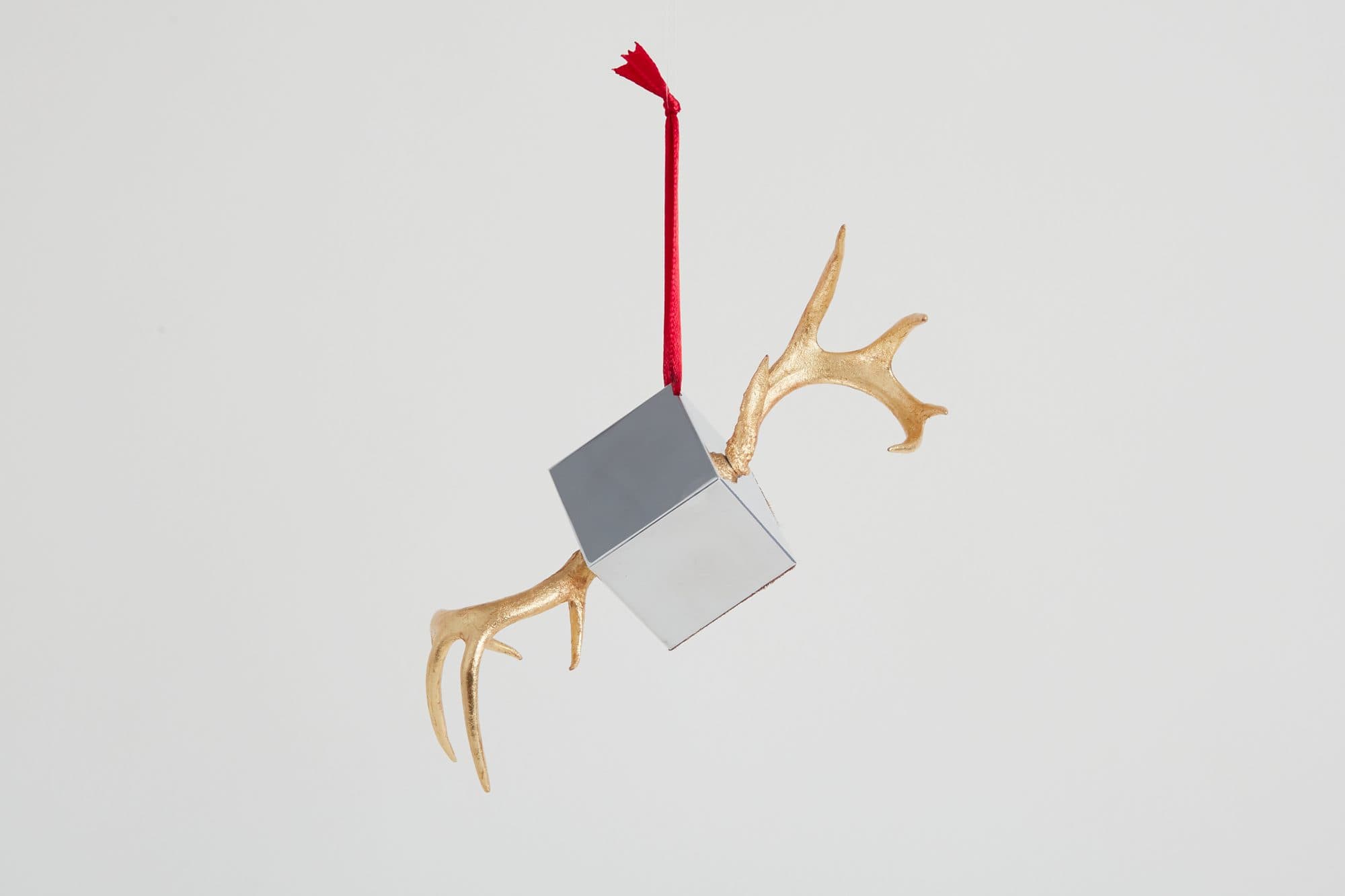 Antler ornament with a grey block and a red ribbon by Art and Guilde