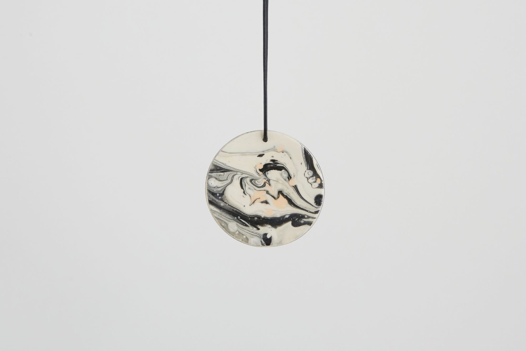 Marbled black and white disc ornament by Malka Dina