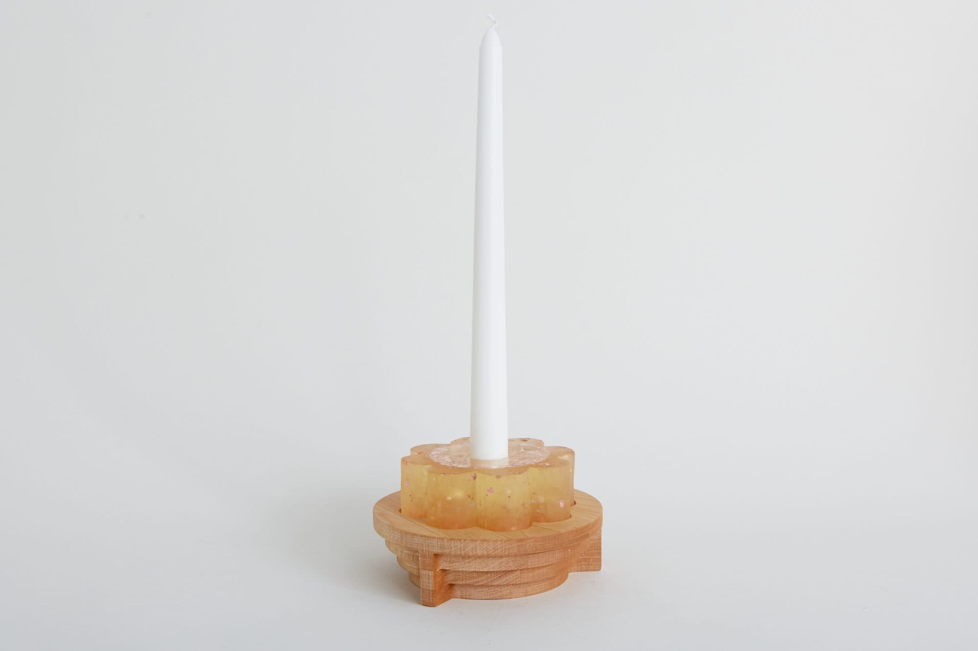 White taper candle in an amber holder by Miduny