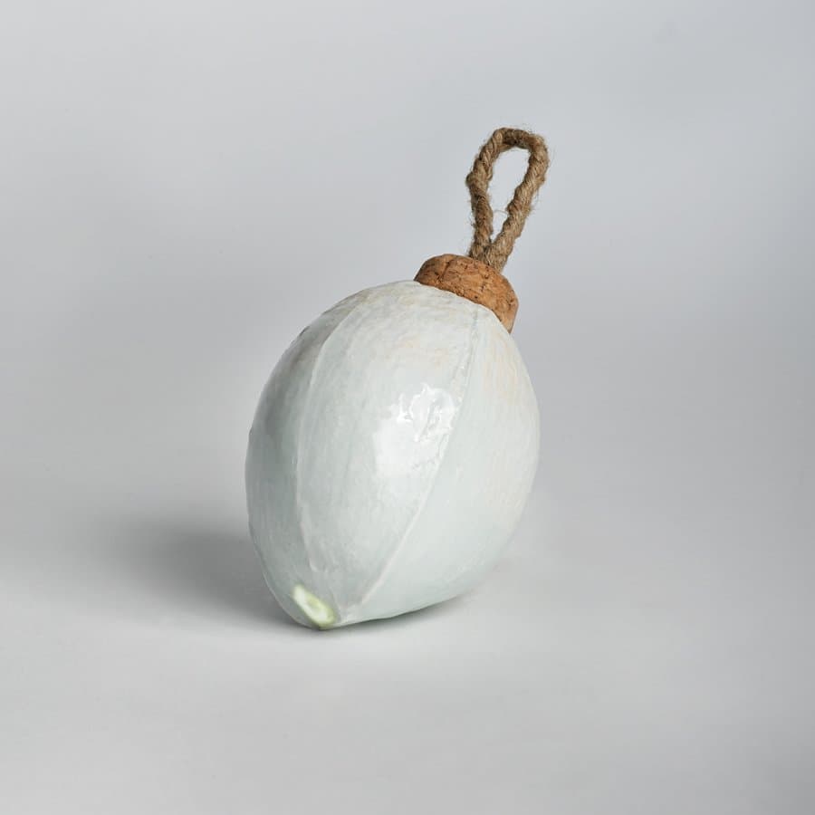 White ceramic egg ornament with a leather loop