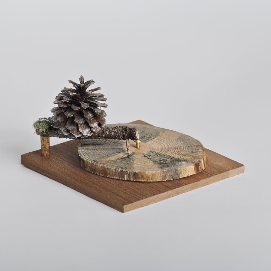 Wood slab ornament with a pinecone