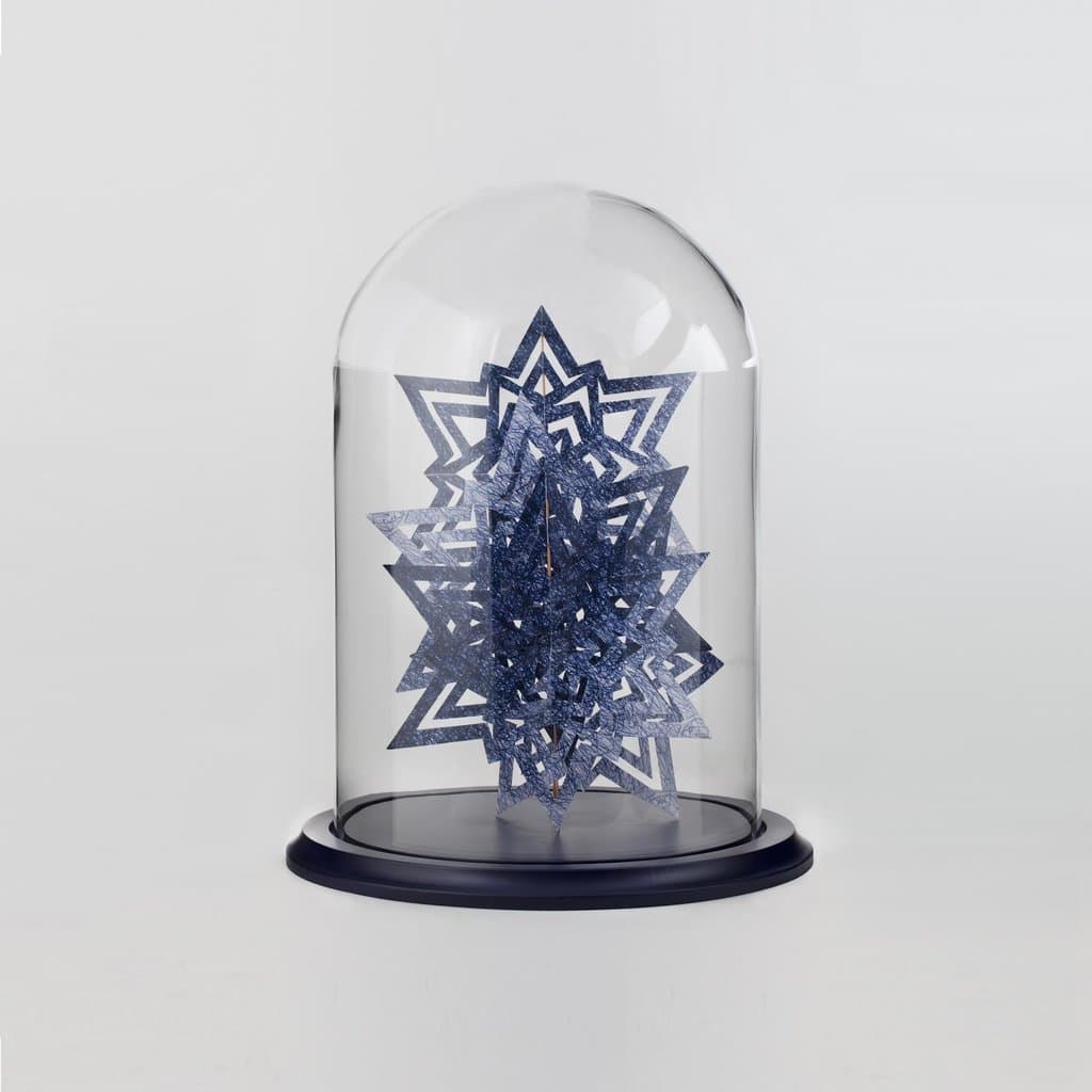 Cut paper snowflake under a glass dome