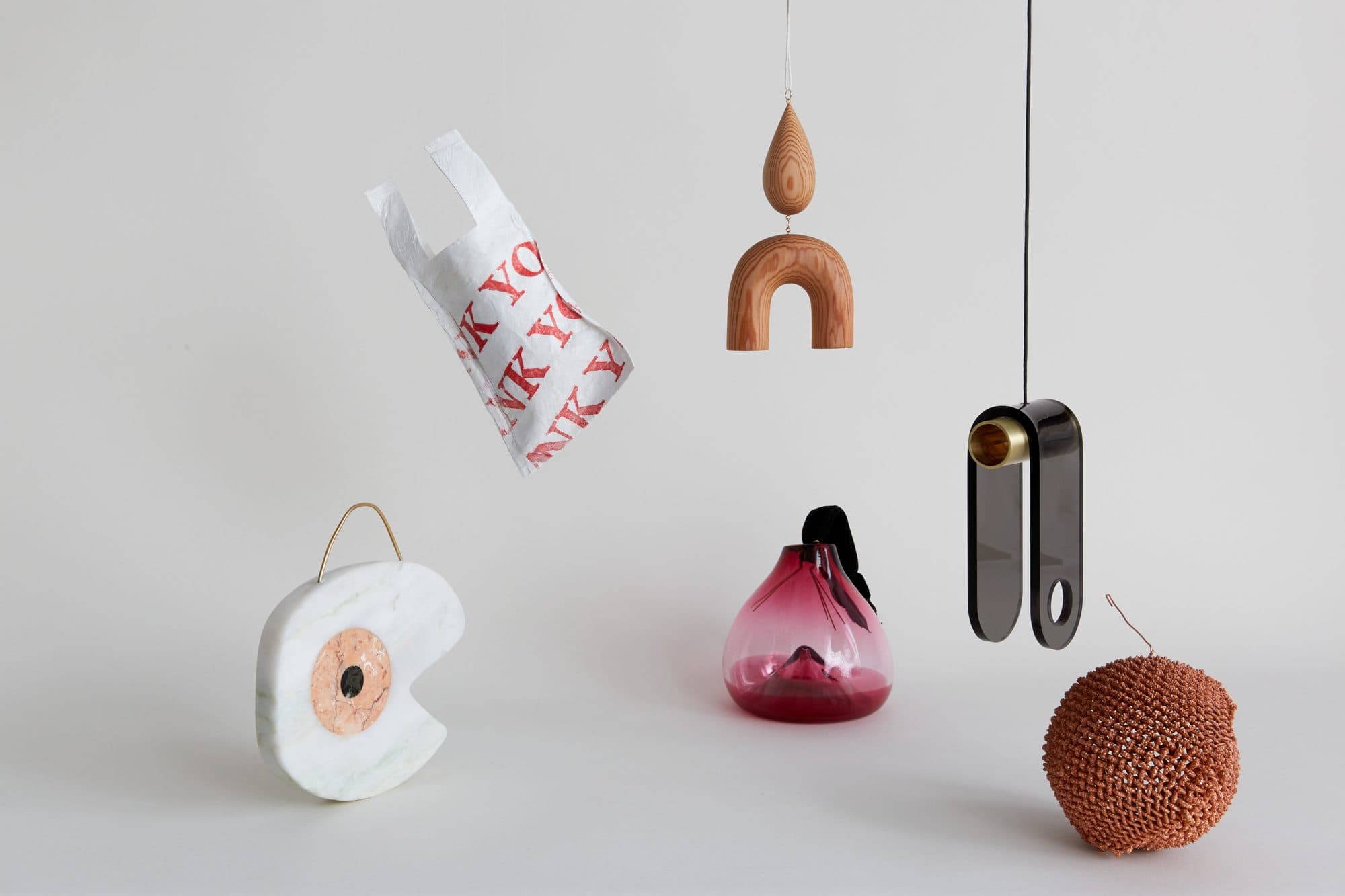 Ornaments including a pink glass drop by Esque, a marble crescent by Merve Kahraman and a printed bag by Zeray Studio