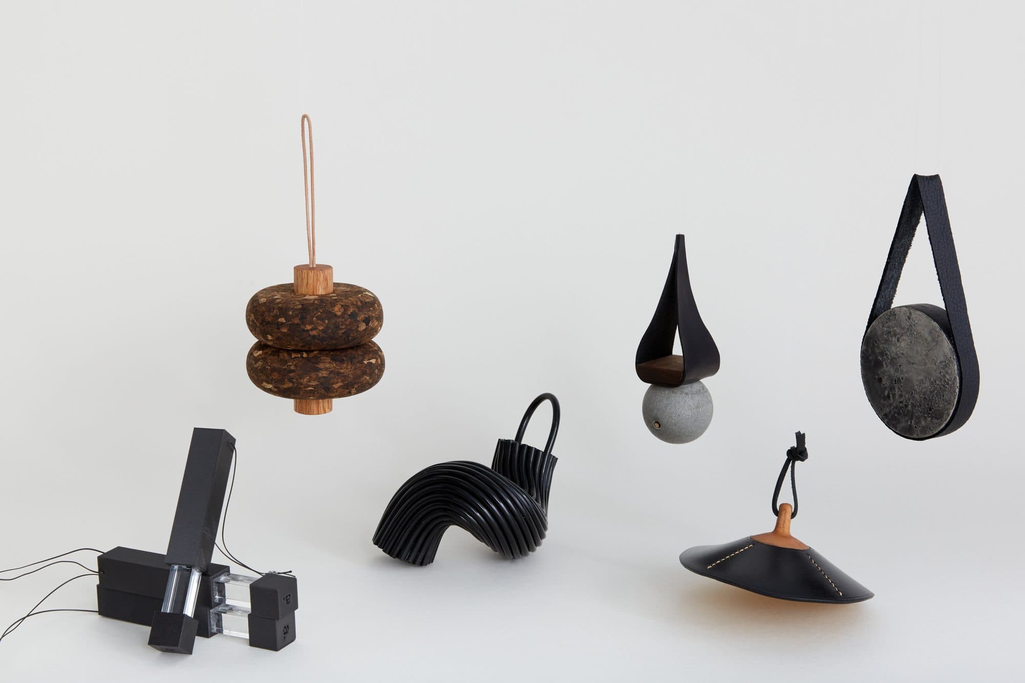 Dark ornaments including a stacked cork piece by Half Halt and a black pendant lamp by Atelier CUB