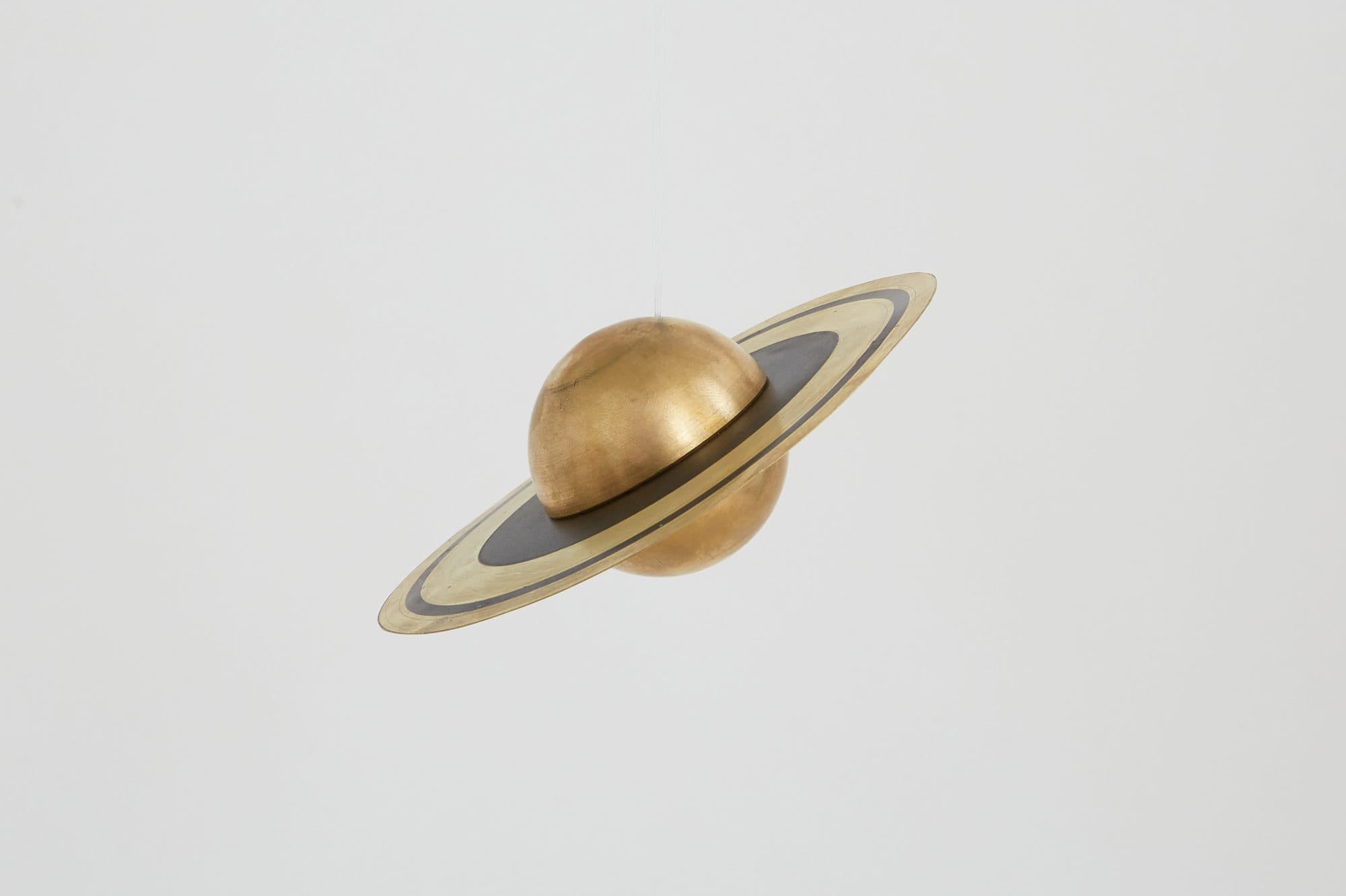 Brass Saturn ornament with a black ring by Richard Clarkson
