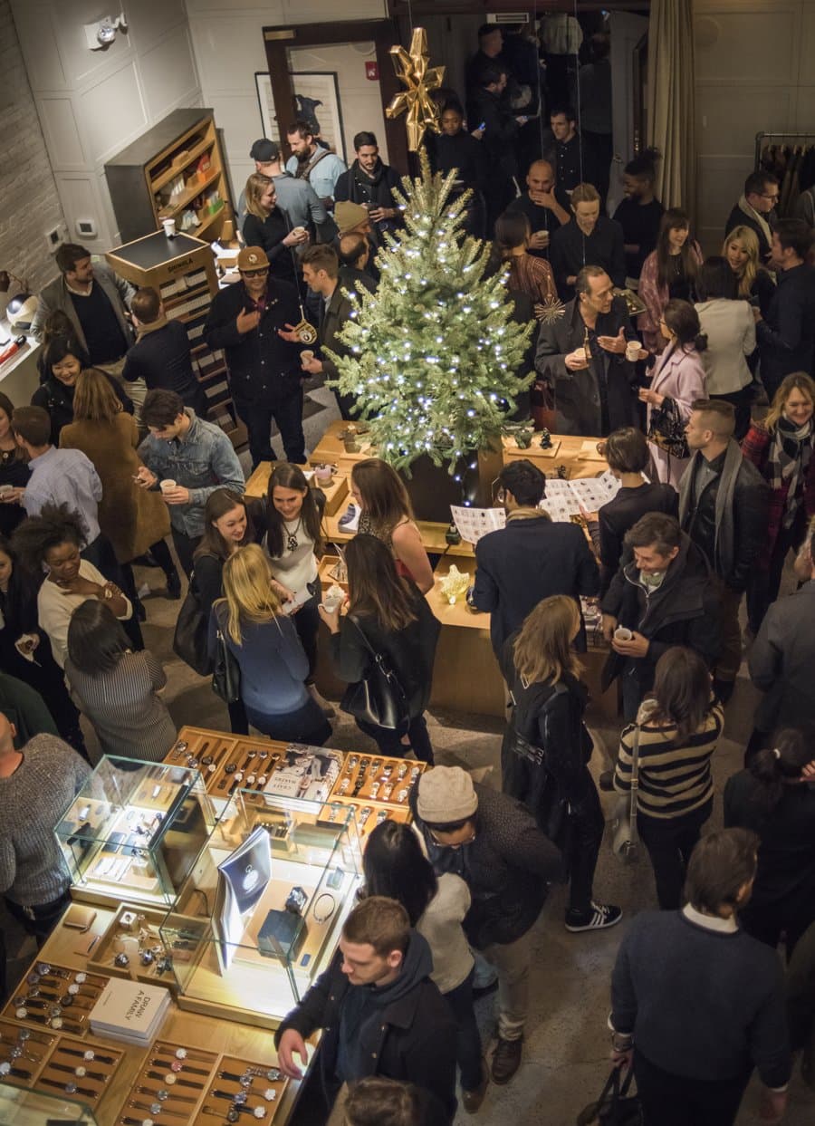 Overhead view of the crowd around the lit tree inside the Shinola TriBeCa store