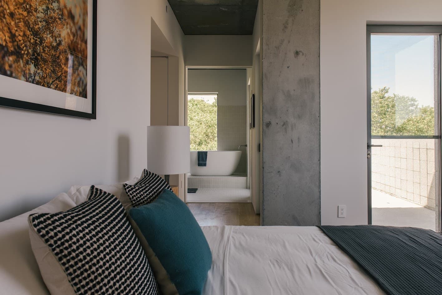 Bedroom with a textured pillow and a concrete column