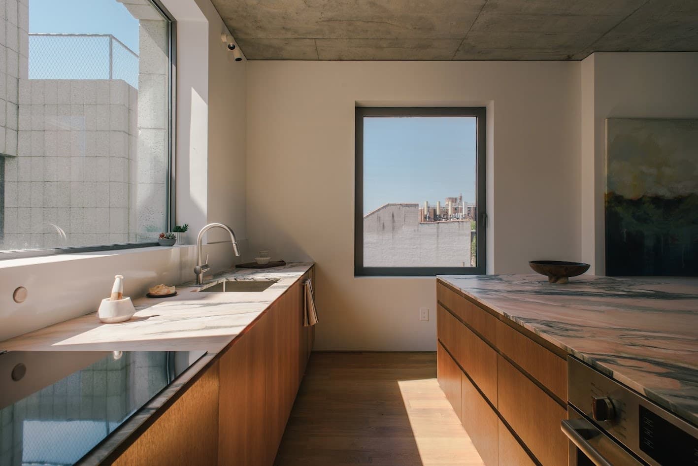 White oak kitchen with a marble island in the 450 Warren penthouse
