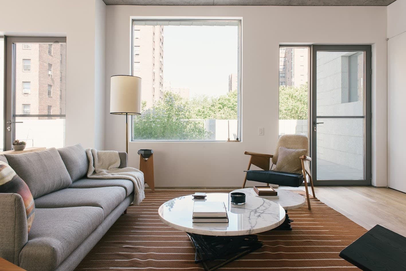 Lounge chairs and a sofa around marble tables