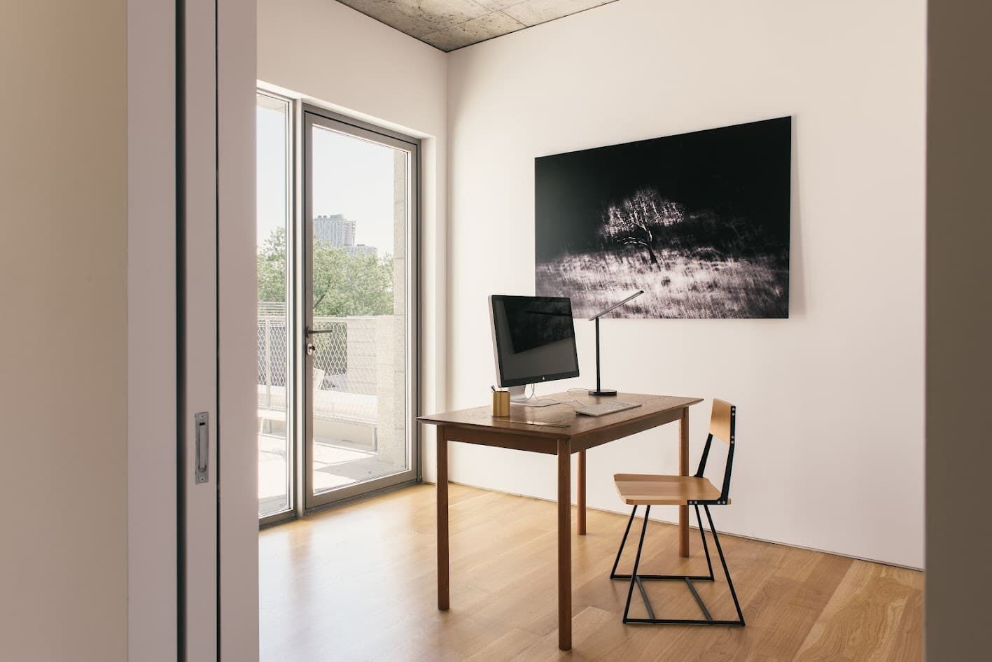 Home office with a wood desk and a dark photograph