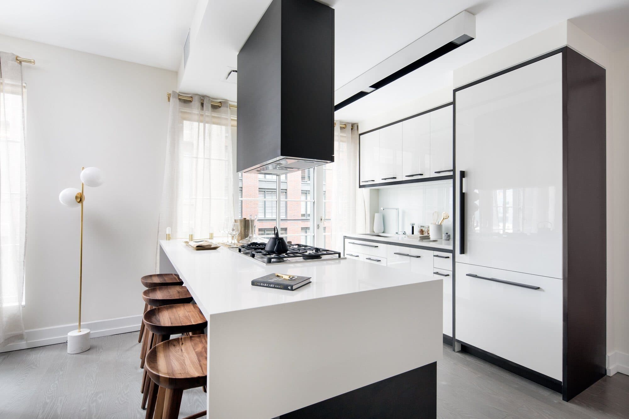 White lacquer kitchen with walnut counter stools in a 70 Charlton model residence