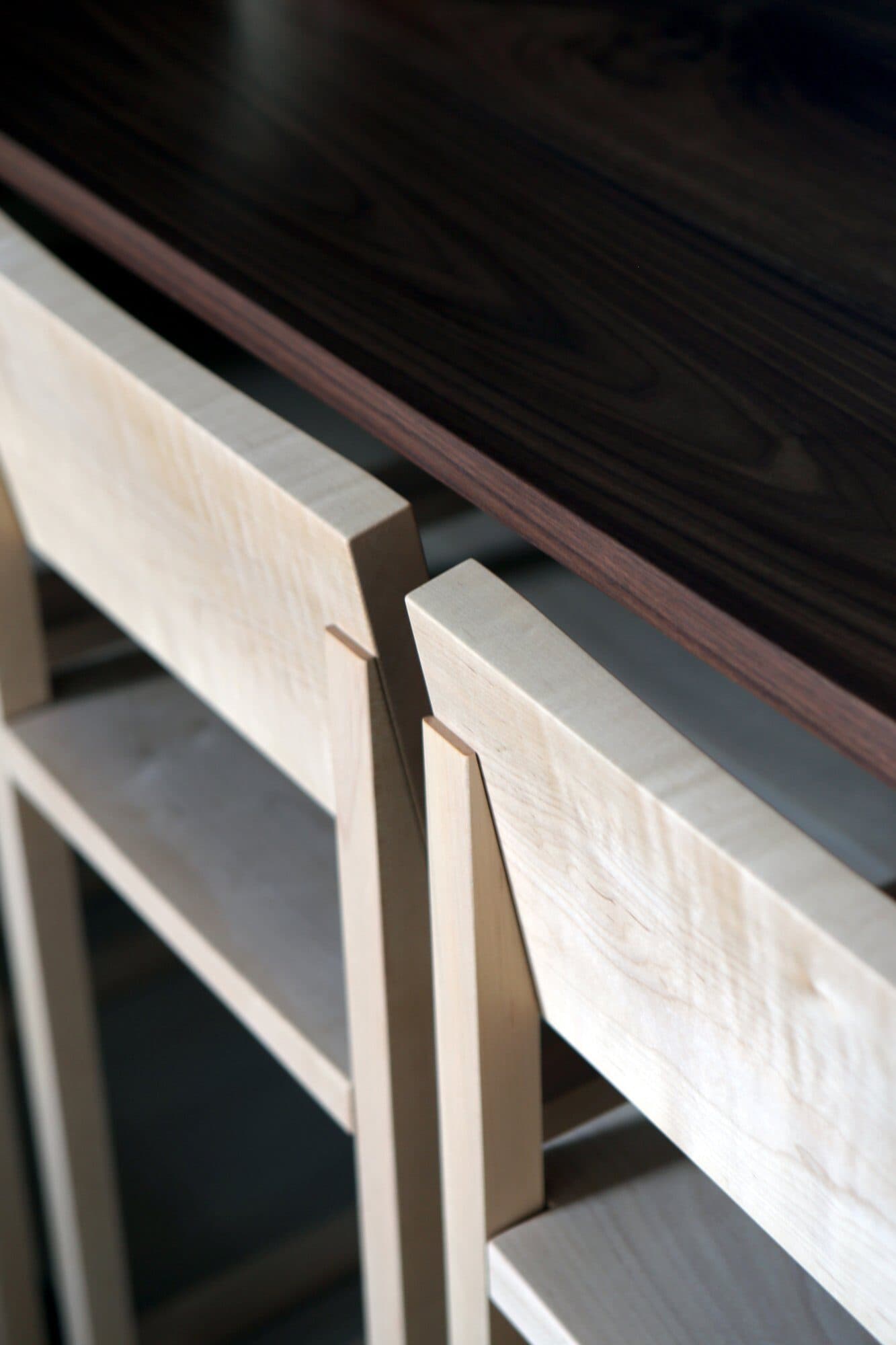 Custom maple stool against the walnut seating counter at 70 Pine