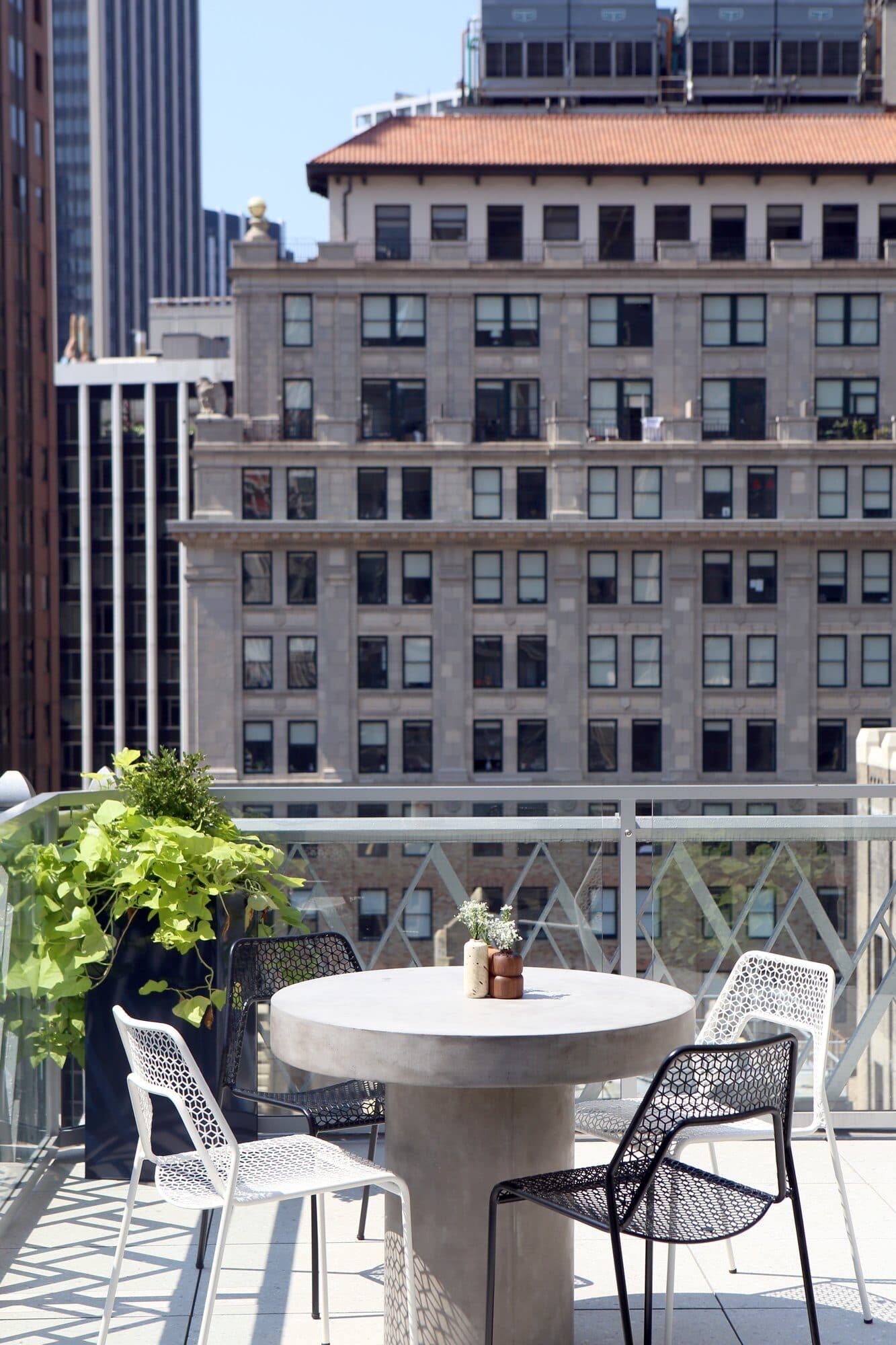 Concrete café table and wire chairs with a historic tower behind
