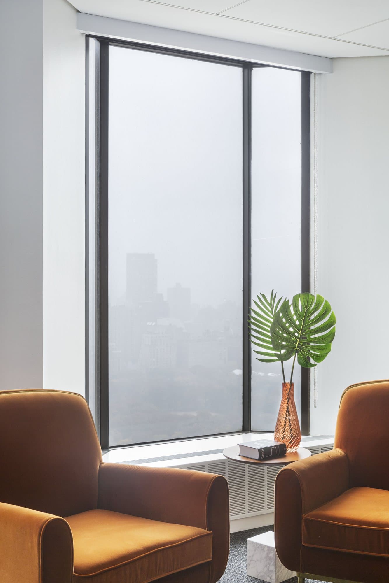 Rust armchairs by a misty window