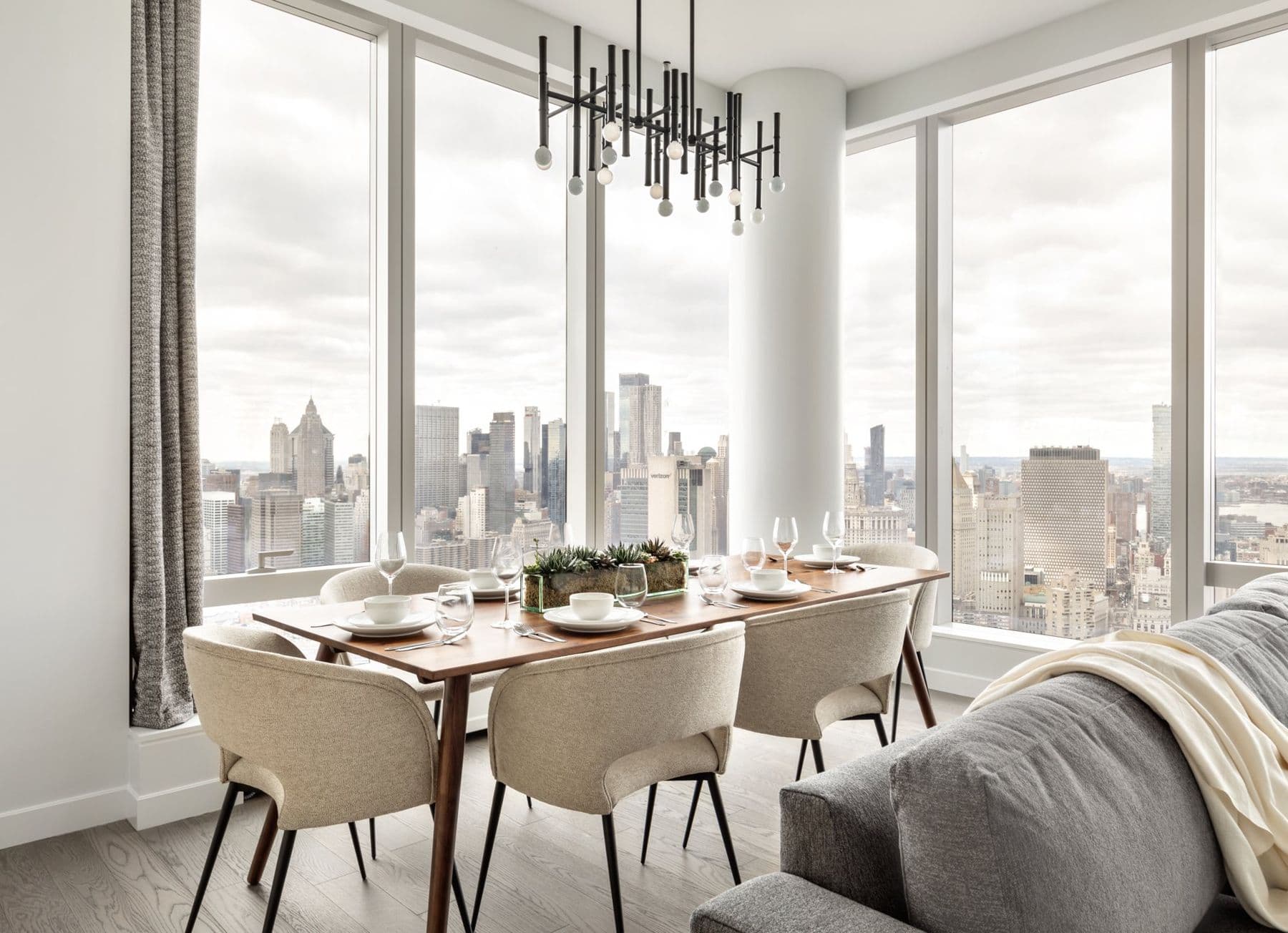 Dining room with a walnut table set against floor-to-ceiling windows over Lower Manhattan