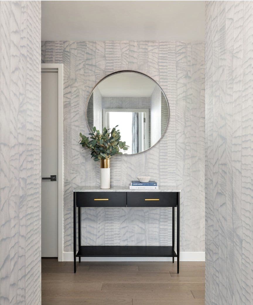 Entry console with a round mirror against textured wallpaper