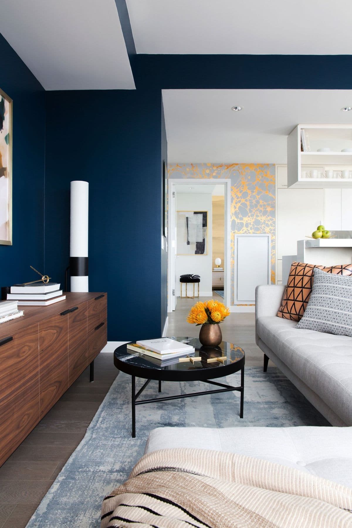 Living room with ink-blue walls and AVO cushions on a white sofa