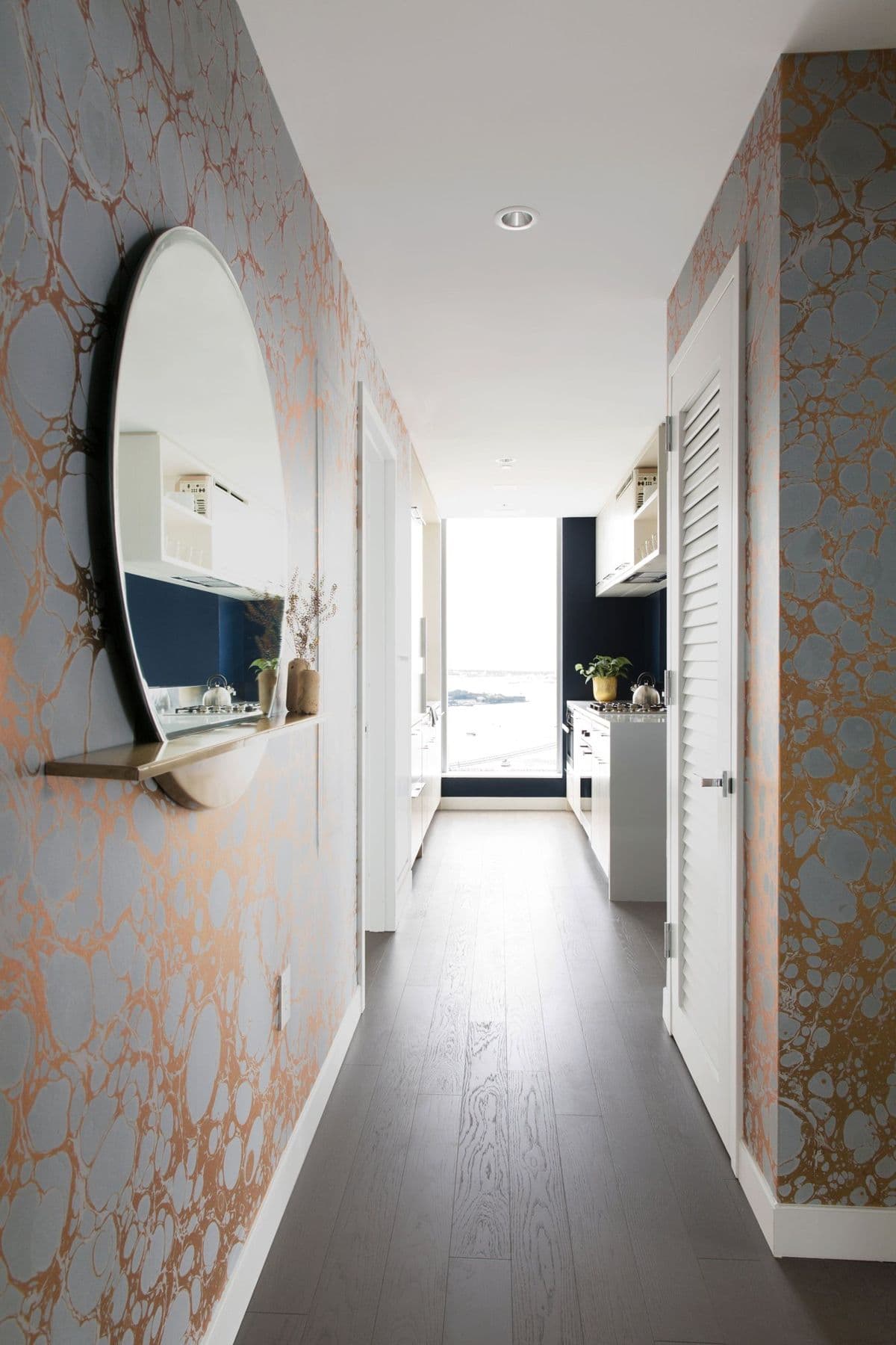 Hallway lined in gold marbled wallpaper